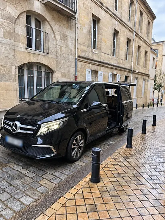 Black Mercedes van parked in front of a stone building in Bordeaux.